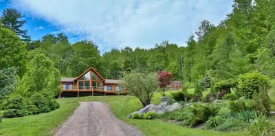 a home in the woods with a dirt road at Stunning Home with Hot Tub Fire Pit & Amazing Views in Hunter