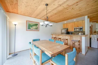 a kitchen and dining room with a wooden table and chairs at Windham Mountain Village Condo in Windham