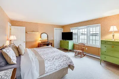 a bedroom with a bed and a dresser and a television at Lake Views and Dock Access - Pittsfield Cottage! in Pittsfield