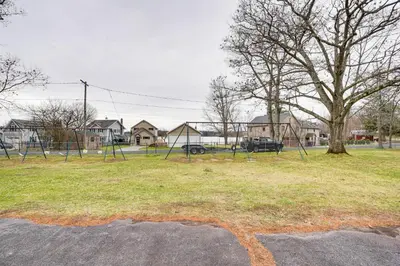 a park with a swing set and a tree at Lake Views and Dock Access - Pittsfield Cottage! in Pittsfield