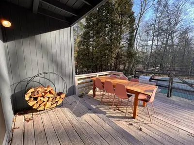 a wooden table and chairs on a wooden deck at Luxury Woodstock Retreat Hot tub and heated pool in Woodstock