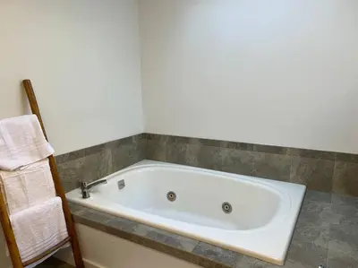 a white bath tub sitting in a bathroom at Luxury Woodstock Retreat Hot tub and heated pool in Woodstock