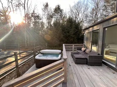 a hot tub sitting on the deck of a house at Luxury Woodstock Retreat Hot tub and heated pool in Woodstock