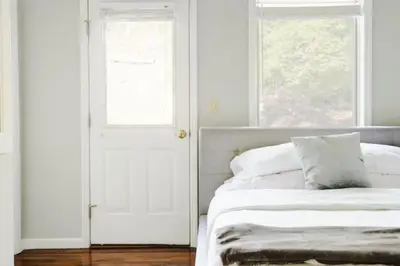 a white bedroom with a bed and a window at Luxury Woodstock Family Retreat with pool hot tub in Woodstock