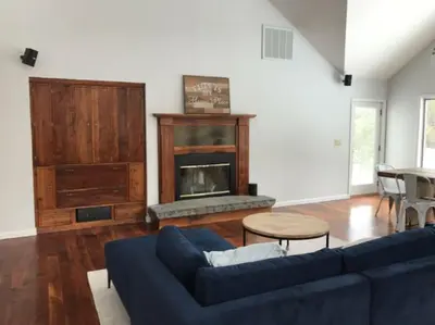 a living room with a blue couch and a fireplace at Luxury Woodstock Family Retreat with pool hot tub in Woodstock