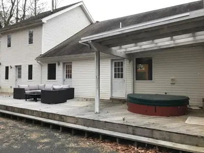 a house with a wooden porch with a patio at Luxury Woodstock Family Retreat with pool hot tub in Woodstock