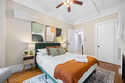 a bedroom with a large bed and a ceiling fan at Vintage Luxe NY - Designer Lofts & Apartments NYC in New York