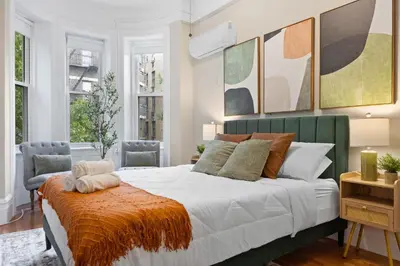 a bedroom with a large bed and two chairs at Vintage Luxe NY - Designer Lofts & Apartments NYC in New York