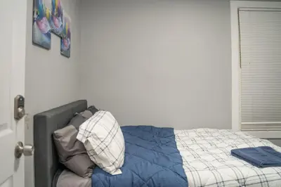 a bed with a blue comforter in a bedroom at Divine Villa and Resort -26 Grace Street Irvington NJ -EWR airport -Prudential - NJIT -Penn station in Irvington