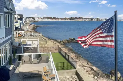 an american flag on the balcony of a house at Sunrise Waterfront Retreat in Milford