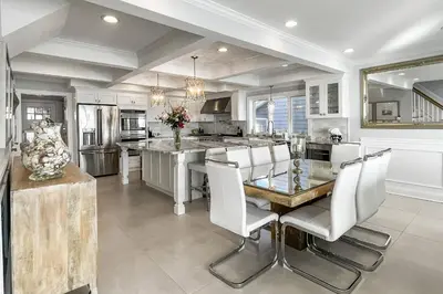 a kitchen with a glass table and white chairs at Sunrise Waterfront Retreat in Milford