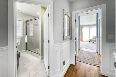 a bathroom with a walk in shower and a glass door at Sunrise Waterfront Retreat in Milford