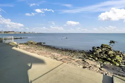 a shadow of a person standing next to a body of water at Sunrise Waterfront Retreat in Milford