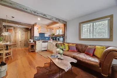a living room with a brown couch and a table at Poconos Cabin Year Round Bliss in Greentown