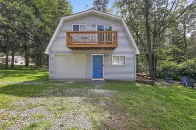a house with a deck and a balcony at Poconos Cabin Year Round Bliss in Greentown