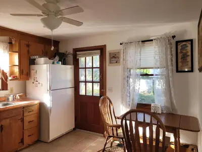 a kitchen with a white refrigerator and a table and chairs at East Granby with AC and WiFi 3 minute to Bradley in East Granby