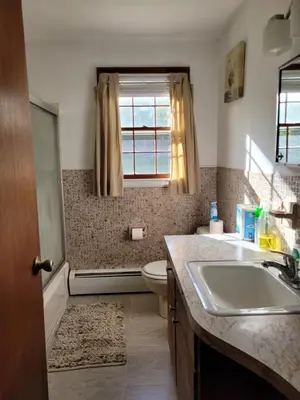 a bathroom with a sink and a toilet and a window at East Granby with AC and WiFi 3 minute to Bradley in East Granby