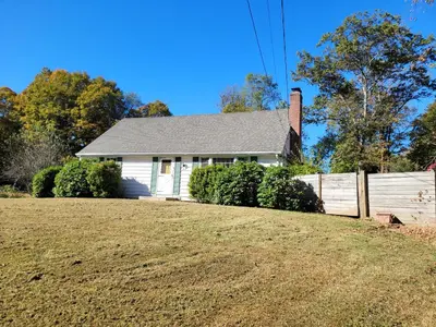 a white house with a fence and a yard at East Granby with AC and WiFi 3 minute to Bradley in East Granby