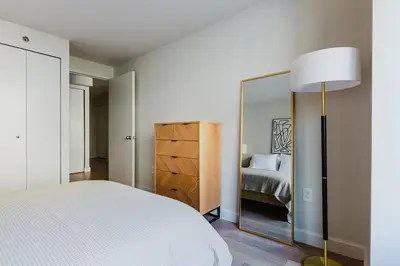 a bedroom with a bed and a mirror at Blueground Jersey City 1bd apartment NYC-1603 in New York
