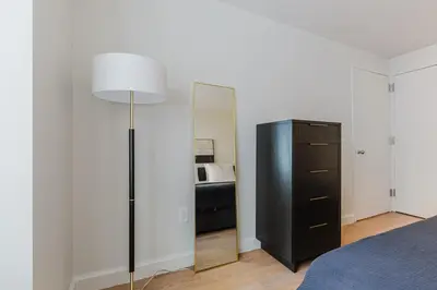 a bedroom with a mirror and a black dresser at Blueground Jersey City 1bd apartment NYC-1603 in New York