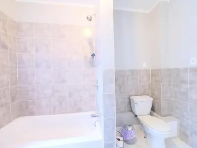 a bathroom with a tub and a toilet and a shower at Serene Two-Bedroom Retreat - close to NYC in Jersey City