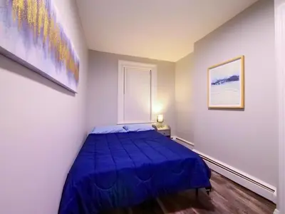 a bedroom with a blue bed and a window at Modern comfort-2BR haven mins to NYC in Jersey City