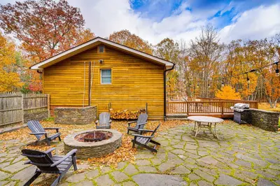 a patio with chairs and a table and a cabin at Private Hot Tub on 10 Acres Cozy Catskill Getaway in Catskill