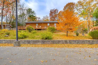a log home in the woods with leaves on the ground at Private Hot Tub on 10 Acres Cozy Catskill Getaway in Catskill