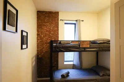 two bunk beds in a room with a window at Family Friendly 4BR 2BA in Prime NYC Location in New York