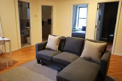 a living room with a couch and a chair at Family Friendly 4BR 2BA in Prime NYC Location in New York