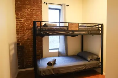 two bunk beds in a room with a window at Family Friendly 4BR 2BA in Prime NYC Location in New York