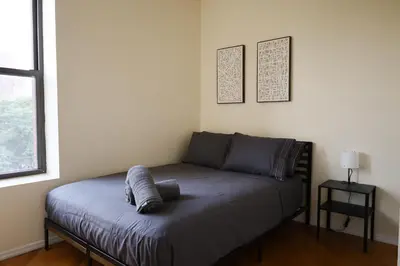a bed in a room with a pillow on it at Family Friendly 4BR 2BA in Prime NYC Location in New York