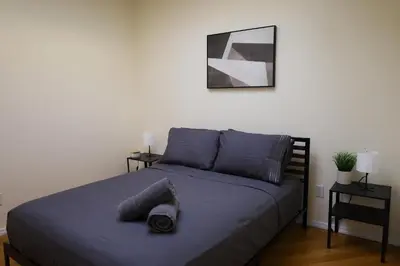 a bed with blue sheets and a hat on it at Family Friendly 4BR 2BA in Prime NYC Location in New York