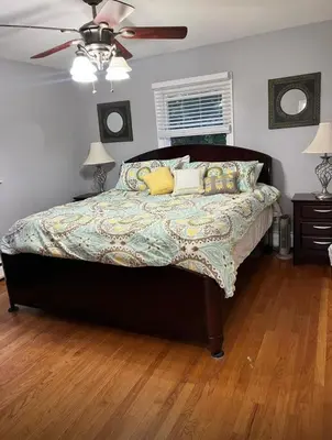 a bedroom with a bed with pillows and a ceiling fan at Beautiful 3 - 4 Bedroom Home Fully Furnished Including Utilities Close to I95 & Train in Stratford