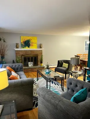 a living room with couches and a fireplace at Beautiful 3 - 4 Bedroom Home Fully Furnished Including Utilities Close to I95 & Train in Stratford