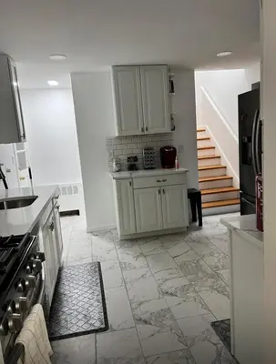a kitchen with white cabinets and a tile floor at Beautiful 3 - 4 Bedroom Home Fully Furnished Including Utilities Close to I95 & Train in Stratford