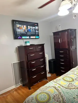 a bedroom with a dresser and a tv on the wall at Beautiful 3 - 4 Bedroom Home Fully Furnished Including Utilities Close to I95 & Train in Stratford