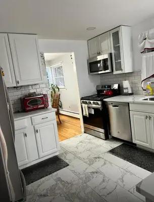 a kitchen with white cabinets and a red microwave at Beautiful 3 - 4 Bedroom Home Fully Furnished Including Utilities Close to I95 & Train in Stratford