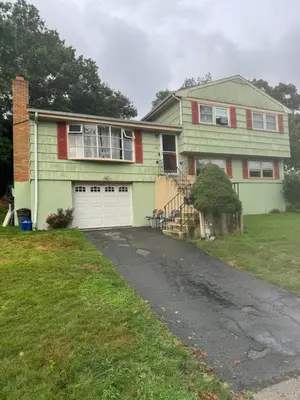 a green house with a driveway in front of it at Beautiful 3 - 4 Bedroom Home Fully Furnished Including Utilities Close to I95 & Train in Stratford