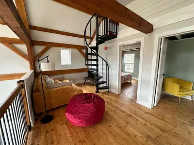 a living room with a spiral staircase in a house at BataviaKill Homestead in Prattsville