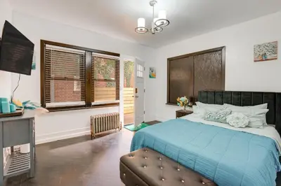 a bedroom with a blue bed and a television at 1 Mi to Train Station Quiet Apartment in Newark in Newark