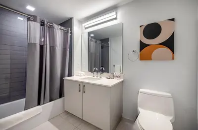 a white bathroom with a toilet and a sink at Modern Apt Close to Downtown in Stamford