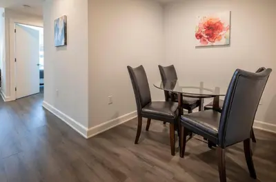 a dining room with a glass table and black chairs at Modern Apt Close to Downtown in Stamford