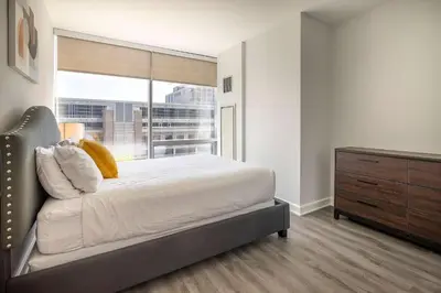 a bedroom with a bed and a dresser and a window at Modern Apt Close to Downtown in Stamford