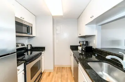 a kitchen with black counter tops and a sink at Comfy Apt Downtown in Stamford