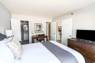 a bedroom with a bed and a flat screen tv at Comfy Apt Downtown in Stamford