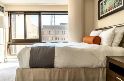 a bedroom with a large bed with a large window at Private Apt Downtown in Stamford