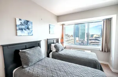 a bedroom with two beds and a large window at Entire Apt Downtown with Gym in Stamford