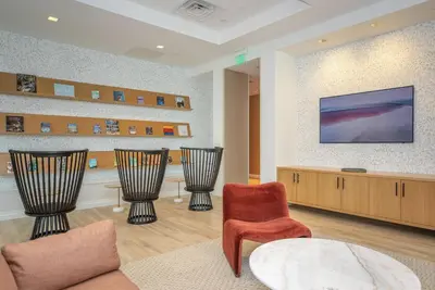 a living room with chairs and a tv on a wall at Entire Apt Downtown with Gym in Stamford