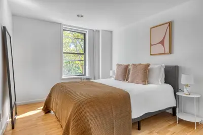 a white bedroom with a bed and a window at Nolita 2br w wd nr SoHo NYC-955 in New York